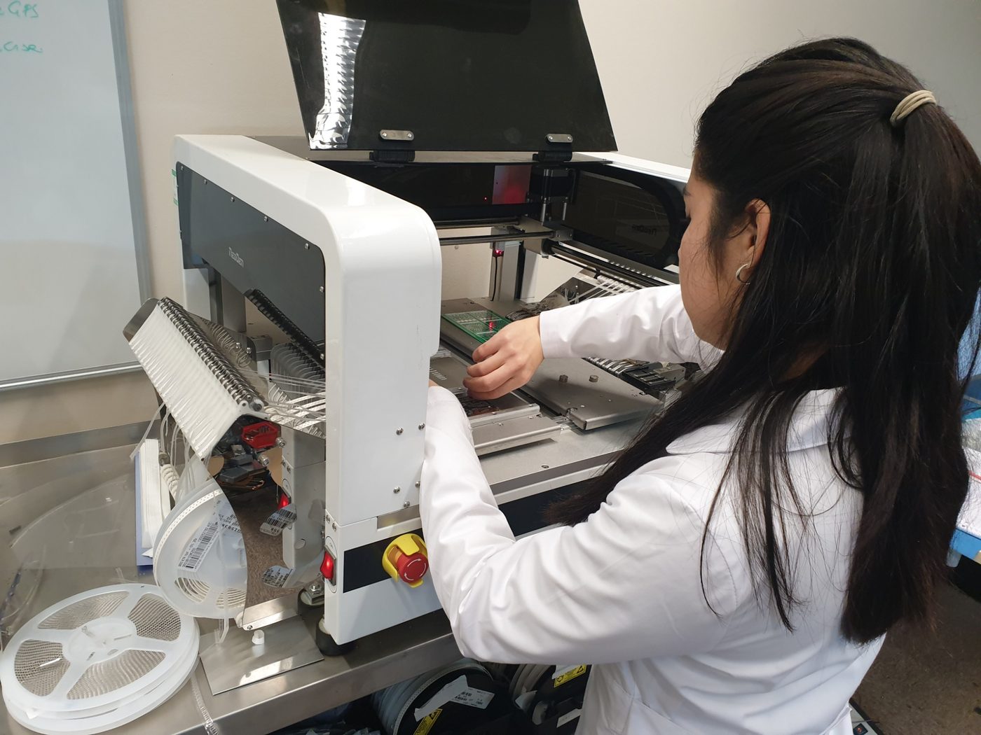 Automated PCB assembly at K9 Electronics' UK facility: a NeoDen pick-and-place machine populating a circuit board with surface-mount components.
